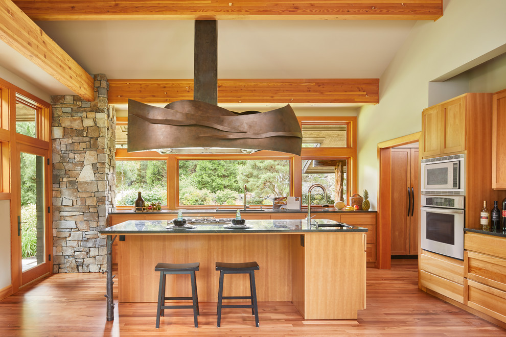 Foto på ett rustikt kök, med skåp i mellenmörkt trä, rostfria vitvaror, en köksö, skåp i shakerstil, fönster som stänkskydd och mellanmörkt trägolv