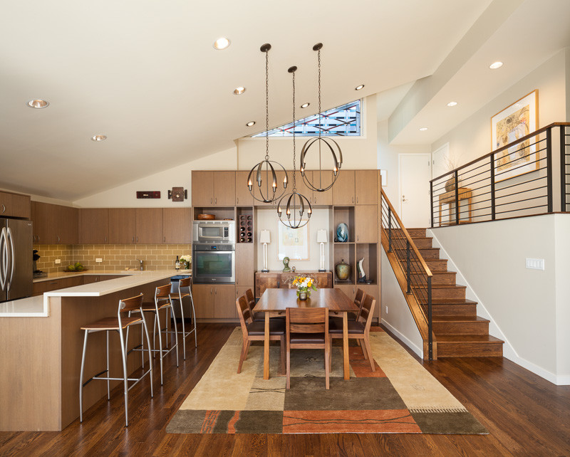 Inspiration for a contemporary l-shaped dark wood floor eat-in kitchen remodel in Seattle with an undermount sink, flat-panel cabinets, medium tone wood cabinets, quartzite countertops, brown backsplash, glass tile backsplash, stainless steel appliances and an island