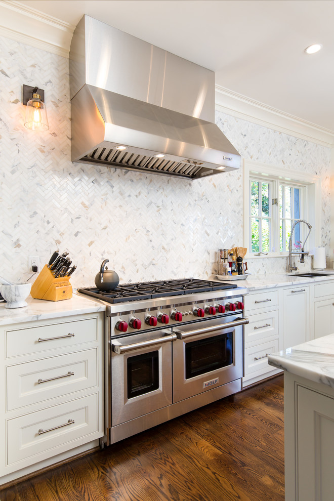 Bild på ett mellanstort lantligt vit vitt kök, med en undermonterad diskho, luckor med infälld panel, vita skåp, marmorbänkskiva, vitt stänkskydd, stänkskydd i marmor, integrerade vitvaror, mörkt trägolv, en köksö och brunt golv