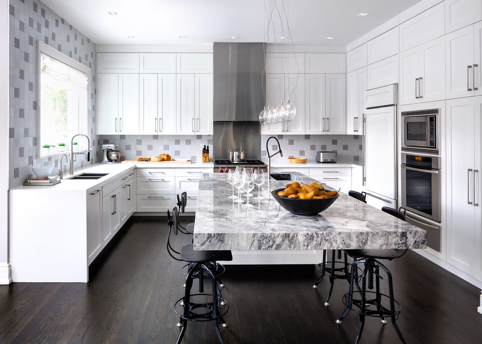 Moderne Küche in U-Form mit Doppelwaschbecken, Schrankfronten im Shaker-Stil, weißen Schränken, bunter Rückwand, Küchengeräten aus Edelstahl, dunklem Holzboden und Kücheninsel in Toronto