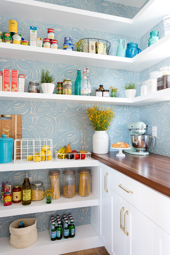 Idées déco pour une arrière-cuisine bord de mer avec un placard à porte shaker, des portes de placard blanches, une crédence bleue, parquet foncé et papier peint.