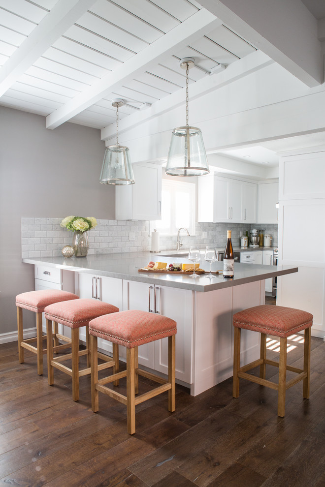 Example of a mid-sized transitional u-shaped medium tone wood floor eat-in kitchen design in Los Angeles with shaker cabinets, white cabinets, gray backsplash, a peninsula, stone tile backsplash and stainless steel appliances