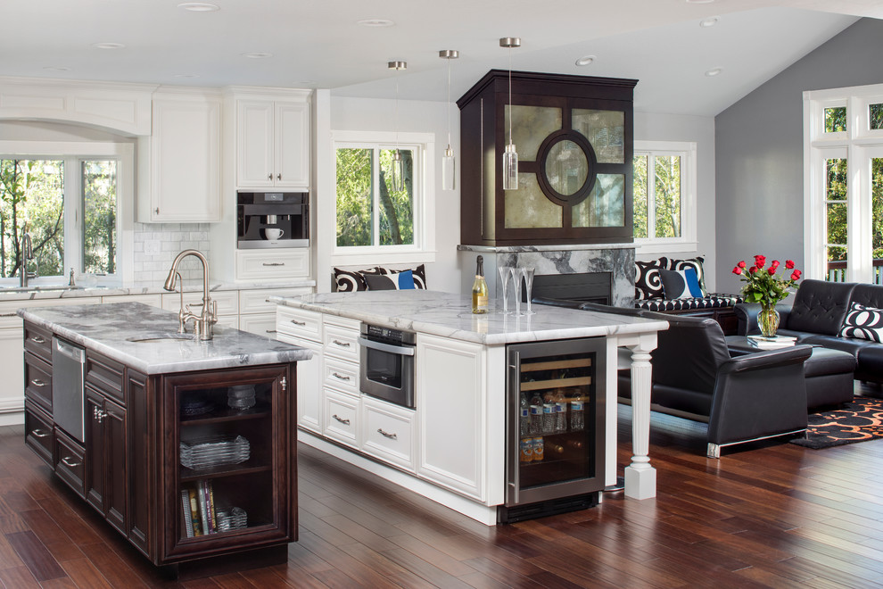 Inspiration for a large timeless dark wood floor open concept kitchen remodel in San Francisco with recessed-panel cabinets, white cabinets, marble countertops, white backsplash, subway tile backsplash, stainless steel appliances and two islands