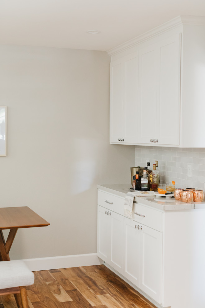 Idéer för att renovera ett mellanstort vintage vit vitt kök, med en rustik diskho, skåp i shakerstil, vita skåp, bänkskiva i kvartsit, vitt stänkskydd, stänkskydd i keramik, rostfria vitvaror, mellanmörkt trägolv och brunt golv