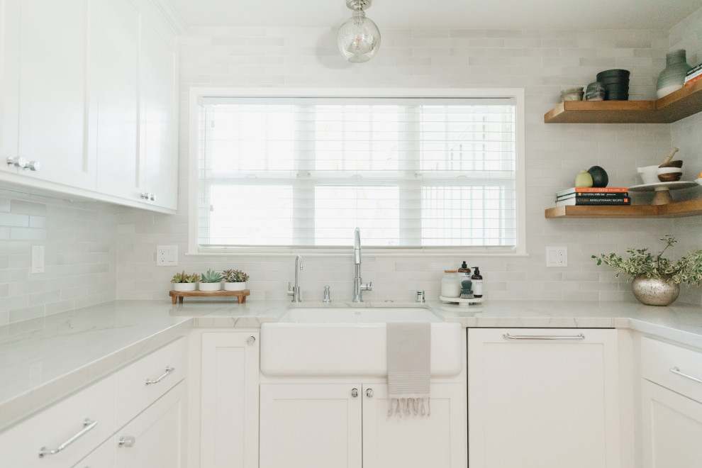 Idéer för att renovera ett mellanstort vintage vit vitt kök, med en rustik diskho, skåp i shakerstil, vita skåp, bänkskiva i kvartsit, vitt stänkskydd, stänkskydd i keramik, rostfria vitvaror, mellanmörkt trägolv och brunt golv