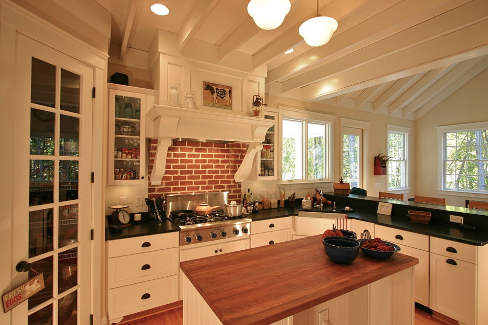 Inredning av ett klassiskt mellanstort kök, med en rustik diskho, skåp i shakerstil, vita skåp, bänkskiva i onyx, vitt stänkskydd, rostfria vitvaror, mellanmörkt trägolv och en köksö