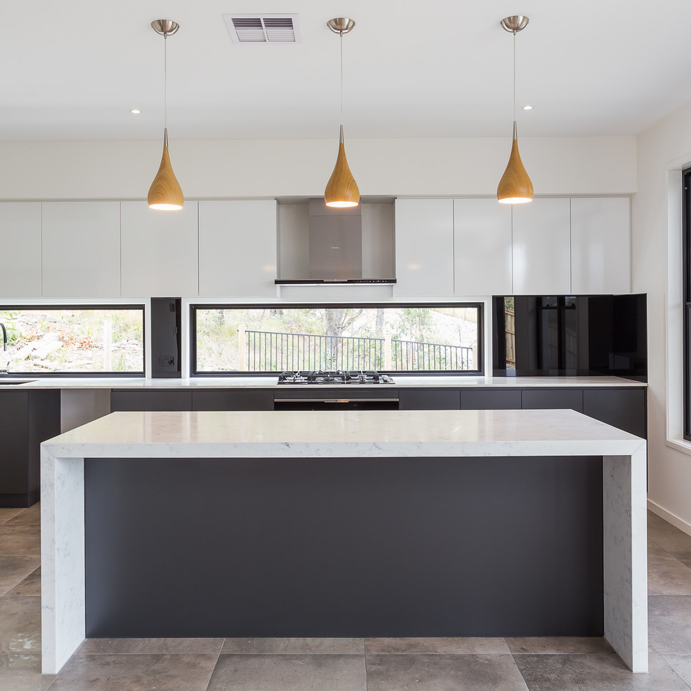 Bild på ett stort funkis linjärt kök med öppen planlösning, med en enkel diskho, luckor med infälld panel, vita skåp, glaspanel som stänkskydd, rostfria vitvaror, klinkergolv i keramik och en köksö