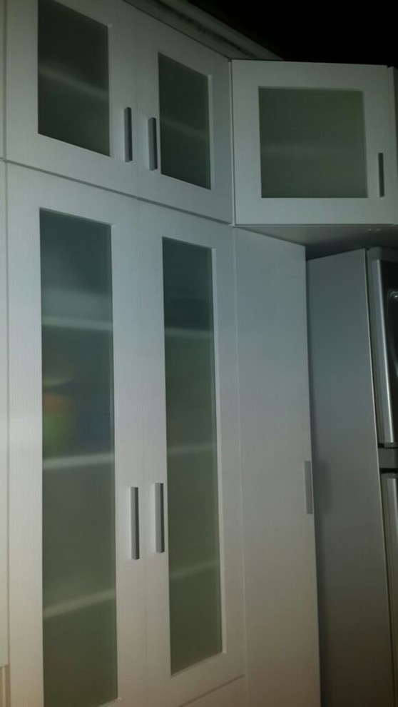 Imagen de cocinas en L actual pequeña cerrada sin isla con armarios con paneles lisos, puertas de armario blancas y suelo de baldosas de cerámica
