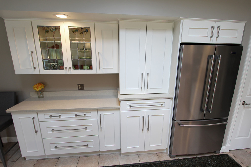 Diseño de cocina comedor clásica renovada grande con armarios con paneles lisos, puertas de armario blancas, electrodomésticos negros y una isla