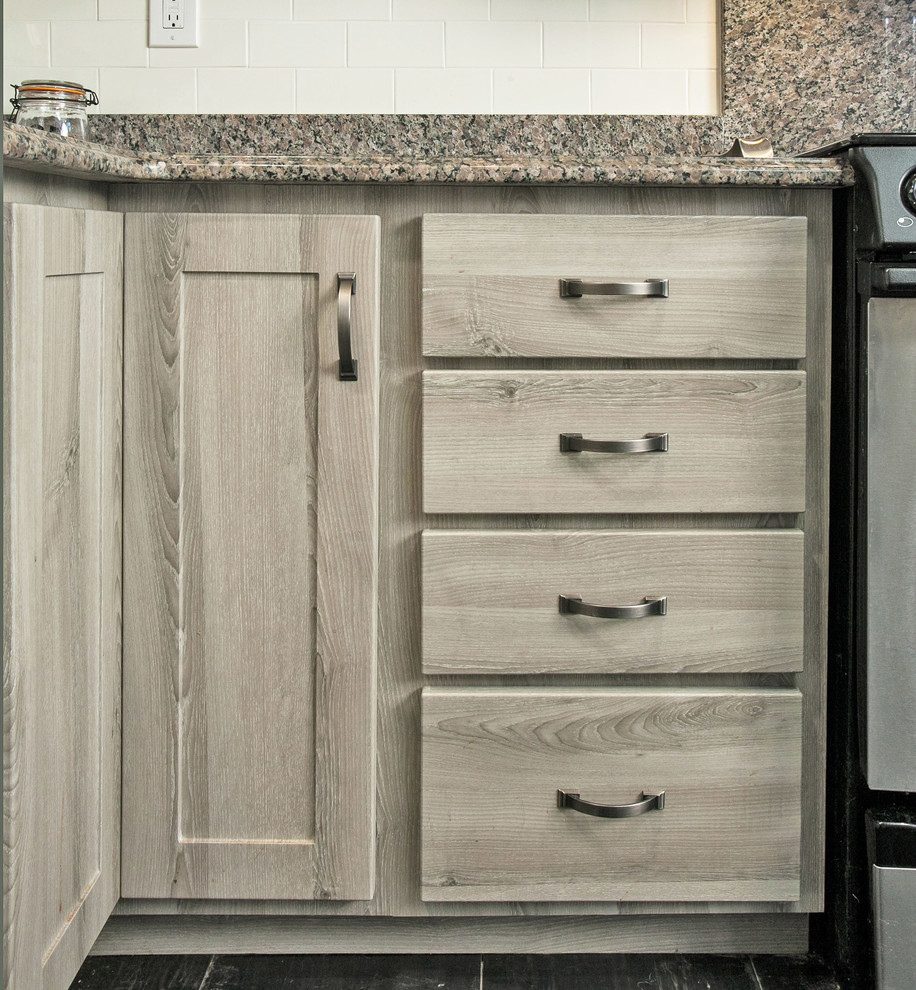 Inredning av ett rustikt mellanstort kök, med en enkel diskho, släta luckor, grå skåp, bänkskiva i glas, vitt stänkskydd, stänkskydd i keramik, svarta vitvaror och travertin golv