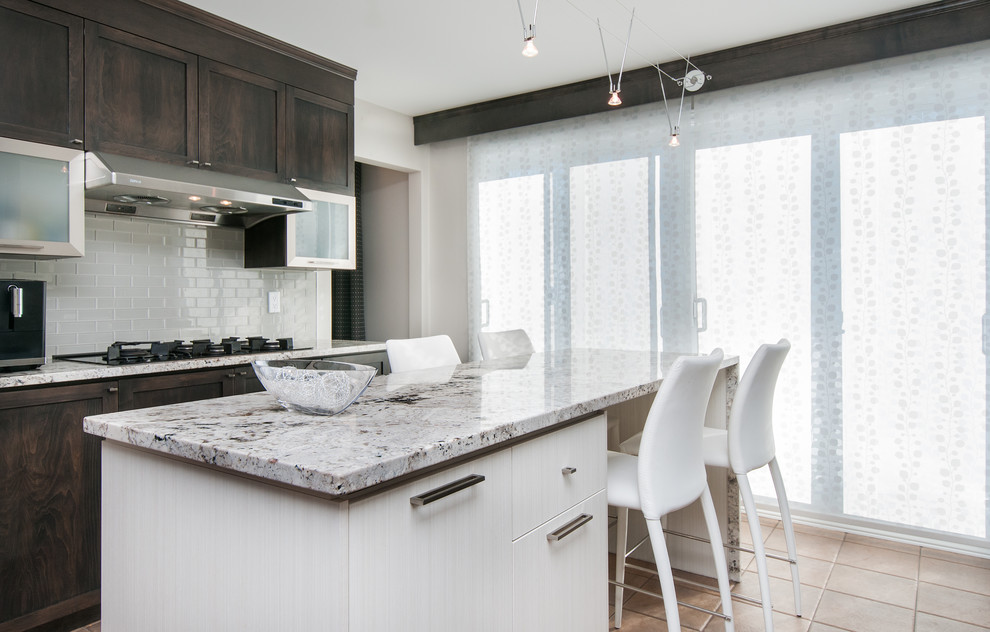 Bild på ett avskilt, mellanstort funkis vit vitt u-kök, med en integrerad diskho, skåp i shakerstil, bruna skåp, granitbänkskiva, grått stänkskydd, stänkskydd i keramik, rostfria vitvaror och en köksö