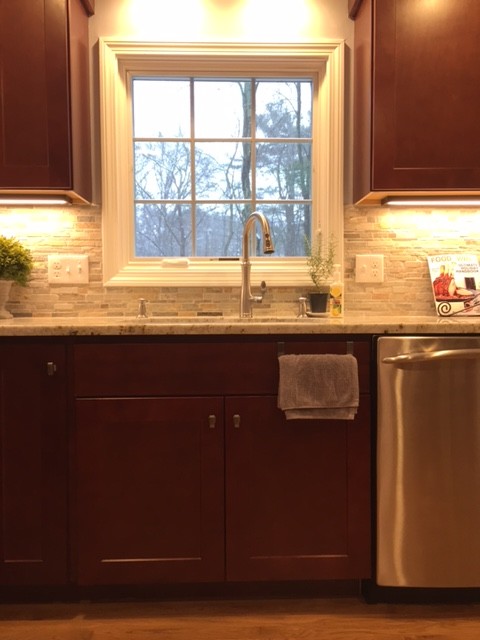 Photo of a small traditional galley kitchen/diner in Boston with a submerged sink, shaker cabinets, dark wood cabinets, engineered stone countertops, multi-coloured splashback, mosaic tiled splashback, stainless steel appliances, light hardwood flooring and a breakfast bar.