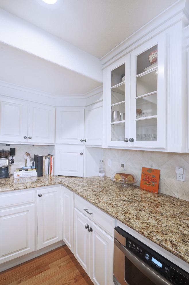 Idéer för stora vintage flerfärgat kök, med en undermonterad diskho, luckor med upphöjd panel, vita skåp, granitbänkskiva, beige stänkskydd, stänkskydd i keramik, rostfria vitvaror, mellanmörkt trägolv, en köksö och brunt golv