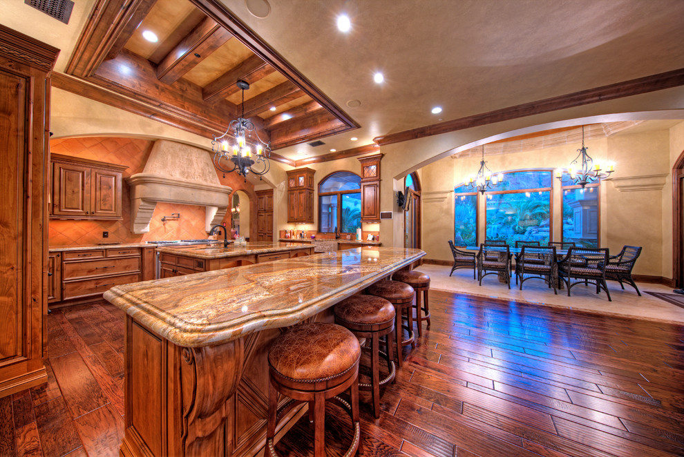 Inspiration for a huge mediterranean l-shaped medium tone wood floor open concept kitchen remodel in Phoenix with a single-bowl sink, raised-panel cabinets, medium tone wood cabinets, granite countertops, paneled appliances and two islands