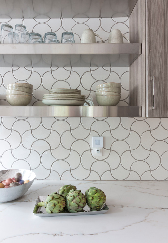 Modelo de cocina contemporánea con puertas de armario grises, salpicadero blanco, salpicadero de azulejos de cerámica, suelo de madera en tonos medios, una isla y suelo marrón