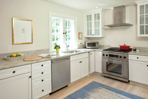 Foto di una cucina a L design chiusa con lavello da incasso, ante con riquadro incassato, ante bianche, top in granito e elettrodomestici in acciaio inossidabile