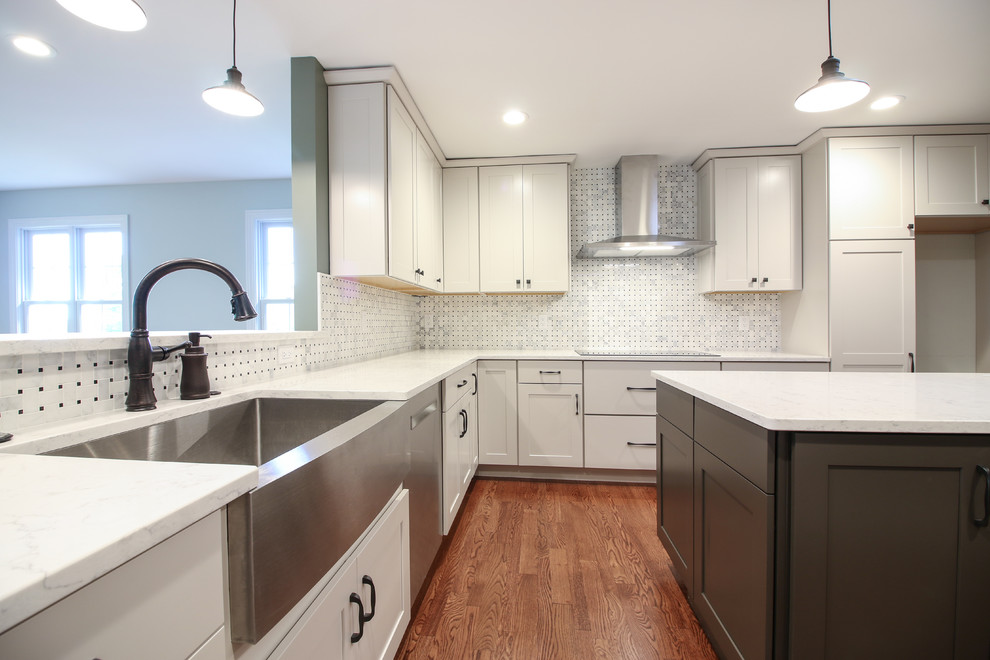 Example of a transitional l-shaped medium tone wood floor and brown floor eat-in kitchen design in St Louis with an undermount sink, white cabinets, granite countertops, multicolored backsplash, ceramic backsplash, stainless steel appliances, an island and white countertops