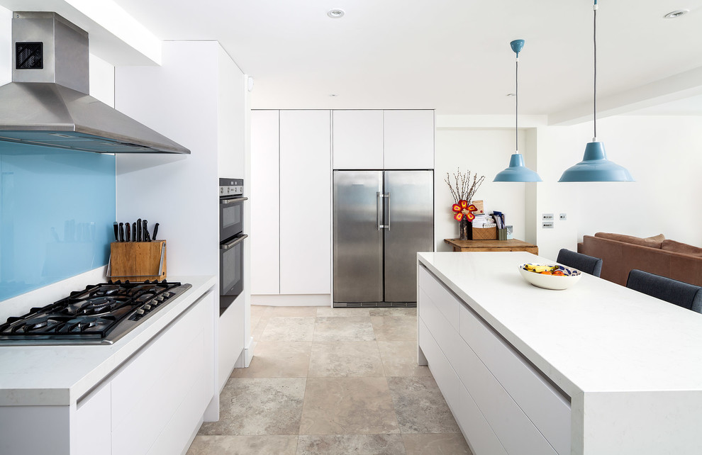 Moderne Küche in L-Form mit flächenbündigen Schrankfronten, weißen Schränken, Küchenrückwand in Blau, Küchengeräten aus Edelstahl und Kücheninsel in London
