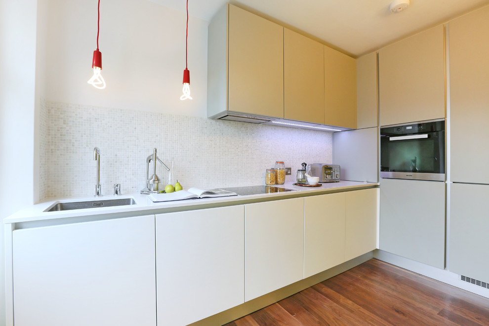 Diseño de cocinas en L contemporánea pequeña cerrada sin isla con armarios con paneles lisos y salpicadero de azulejos de piedra