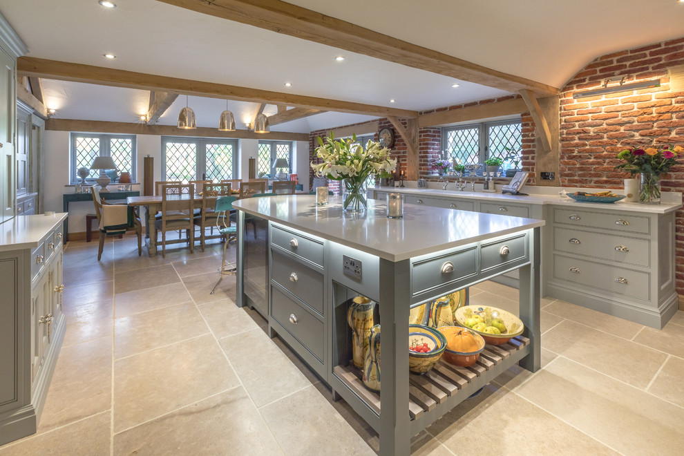 Photo of a medium sized farmhouse galley kitchen/diner in Sussex with a submerged sink, recessed-panel cabinets, grey cabinets, quartz worktops, an island, beige floors and white worktops.