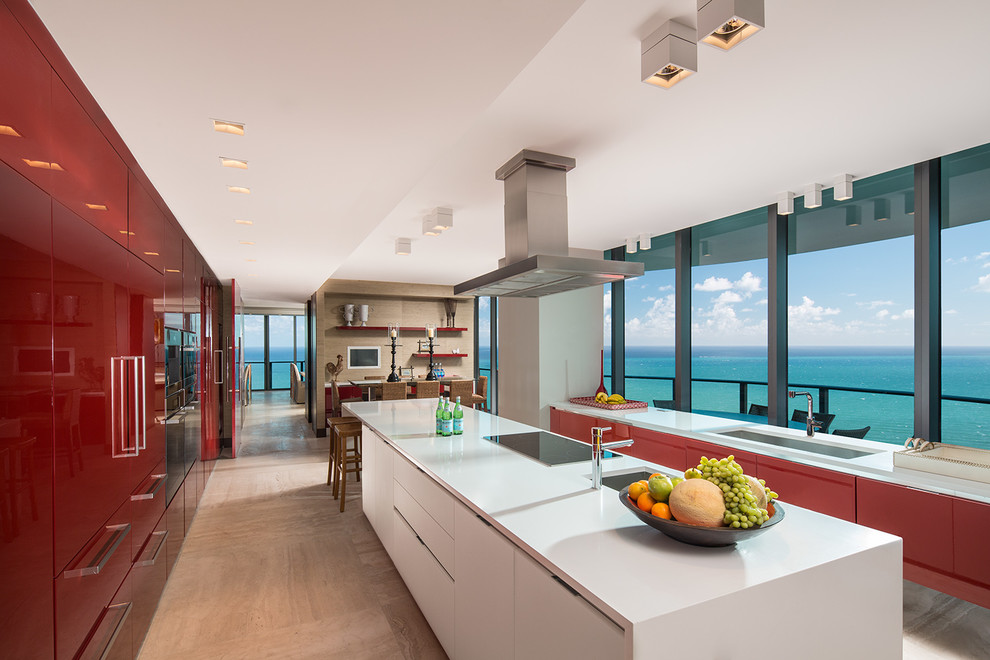 На фото: параллельная, глянцевая кухня в современном стиле с врезной мойкой, плоскими фасадами, красными фасадами и островом с