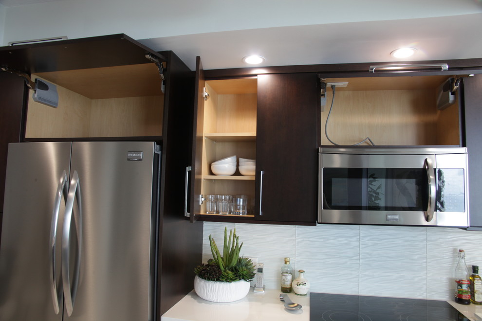 Foto de cocina marinera con armarios con paneles lisos, puertas de armario de madera en tonos medios, salpicadero blanco y electrodomésticos de acero inoxidable