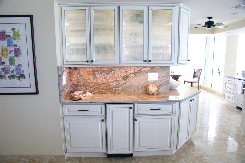 Inspiration for a coastal marble floor and multicolored floor kitchen remodel in Miami with glass-front cabinets, white cabinets, quartzite countertops and stainless steel appliances