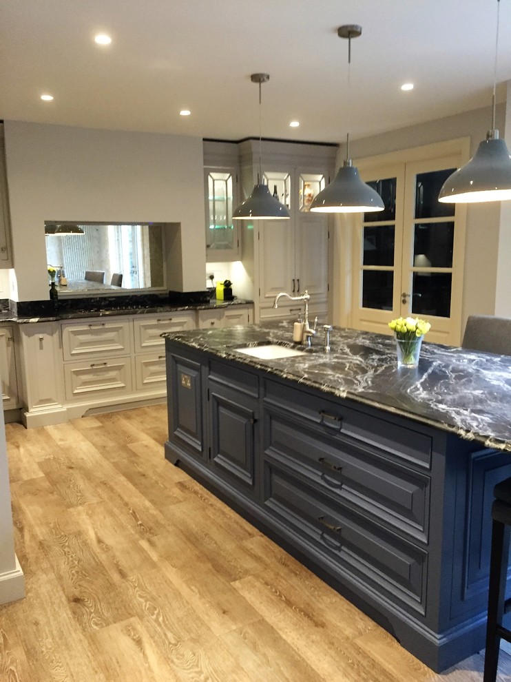 Design ideas for a medium sized classic u-shaped open plan kitchen in Dublin with an integrated sink, raised-panel cabinets, grey cabinets, granite worktops, mirror splashback, stainless steel appliances and an island.