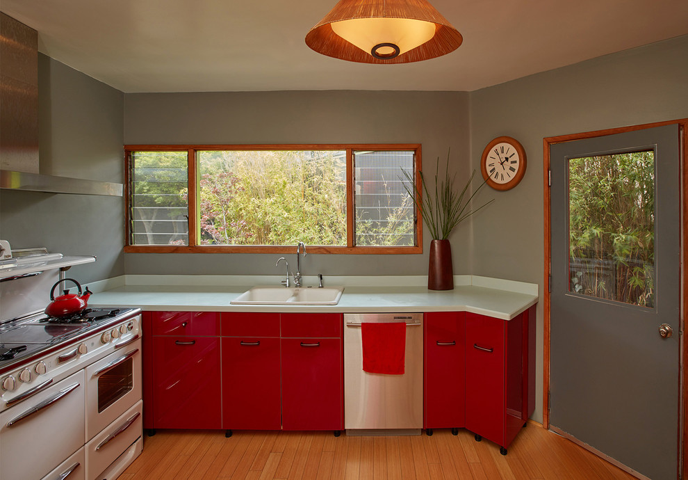 Retro Küche mit flächenbündigen Schrankfronten, roten Schränken, Laminat-Arbeitsplatte, Küchengeräten aus Edelstahl und Bambusparkett in Los Angeles