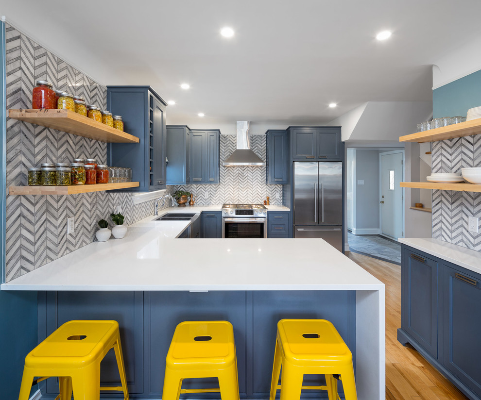 Foto på ett mellanstort vintage kök, med en dubbel diskho, luckor med infälld panel, blå skåp, laminatbänkskiva, flerfärgad stänkskydd, stänkskydd i keramik, rostfria vitvaror, ljust trägolv och en halv köksö