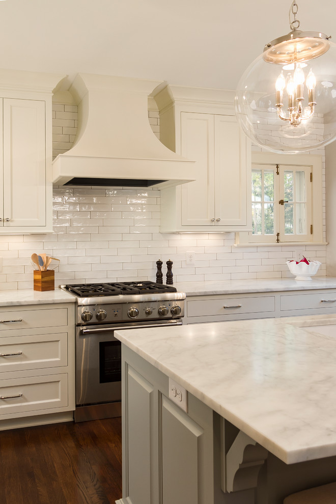 Bild på ett stort vintage kök och matrum, med en undermonterad diskho, luckor med infälld panel, vita skåp, marmorbänkskiva, vitt stänkskydd, stänkskydd i keramik, rostfria vitvaror, mörkt trägolv, en köksö och brunt golv