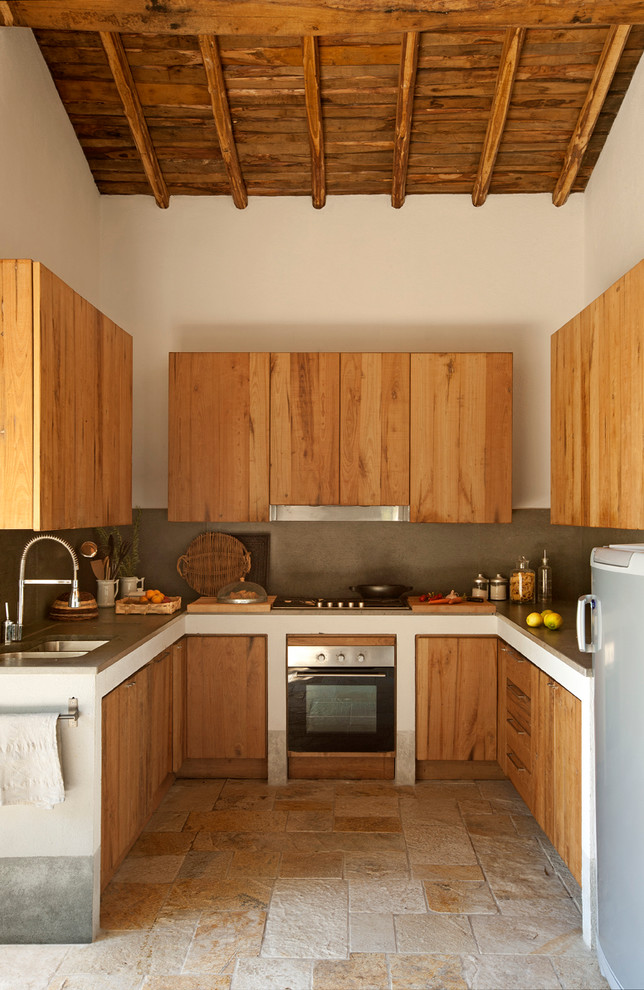 Пример оригинального дизайна: п-образная кухня в стиле кантри с врезной мойкой, плоскими фасадами, фасадами цвета дерева среднего тона и техникой из нержавеющей стали