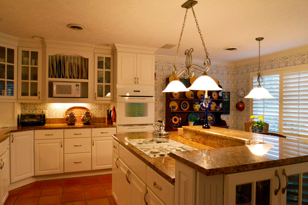 Geschlossene, Mittelgroße Klassische Küche in U-Form mit Waschbecken, profilierten Schrankfronten, weißen Schränken, Granit-Arbeitsplatte, weißen Elektrogeräten, Terrakottaboden und Kücheninsel in Sonstige