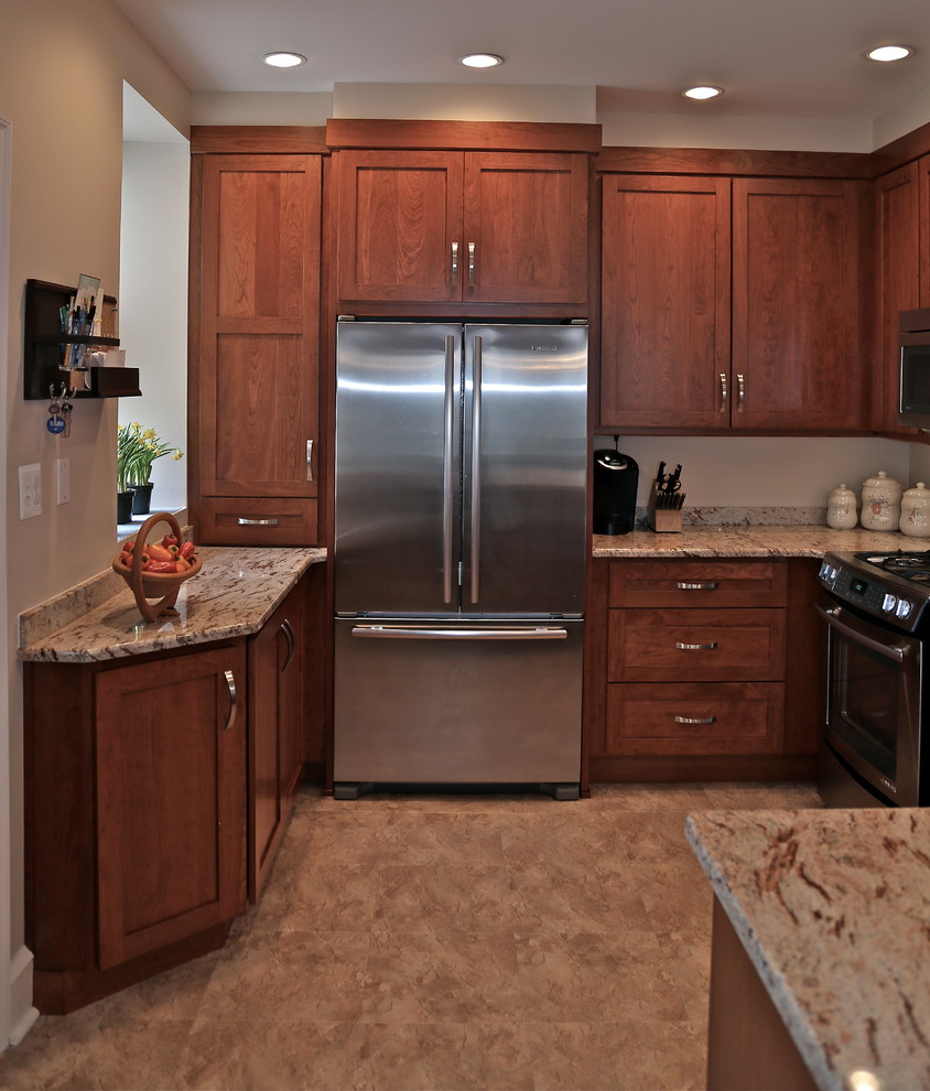 Exempel på ett mellanstort klassiskt kök och matrum, med en undermonterad diskho, luckor med infälld panel, skåp i mellenmörkt trä, granitbänkskiva, flerfärgad stänkskydd, rostfria vitvaror och mellanmörkt trägolv