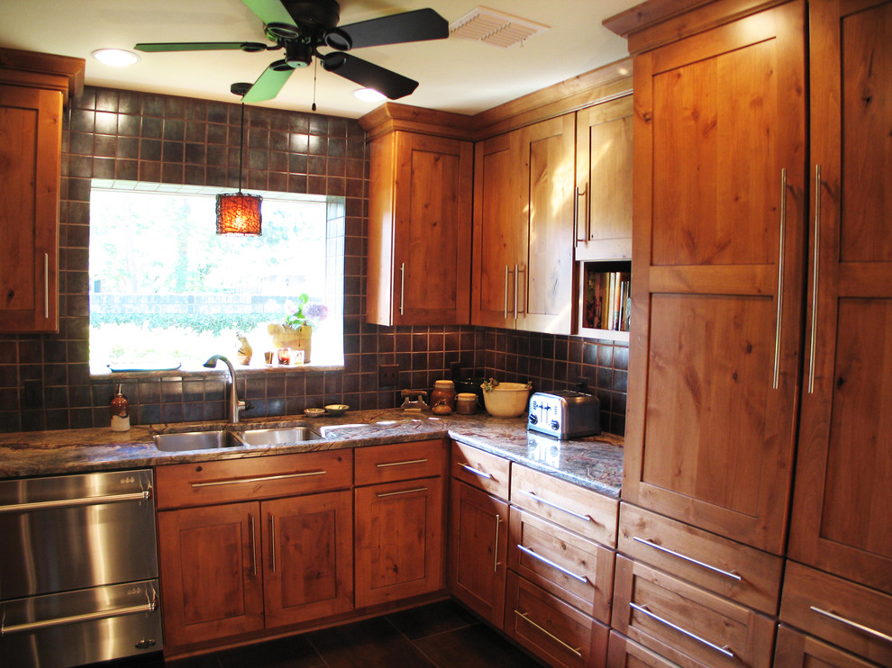 Exempel på ett mellanstort klassiskt u-kök, med en undermonterad diskho, släta luckor, skåp i mellenmörkt trä, granitbänkskiva, brunt stänkskydd, stänkskydd i keramik, rostfria vitvaror och klinkergolv i keramik
