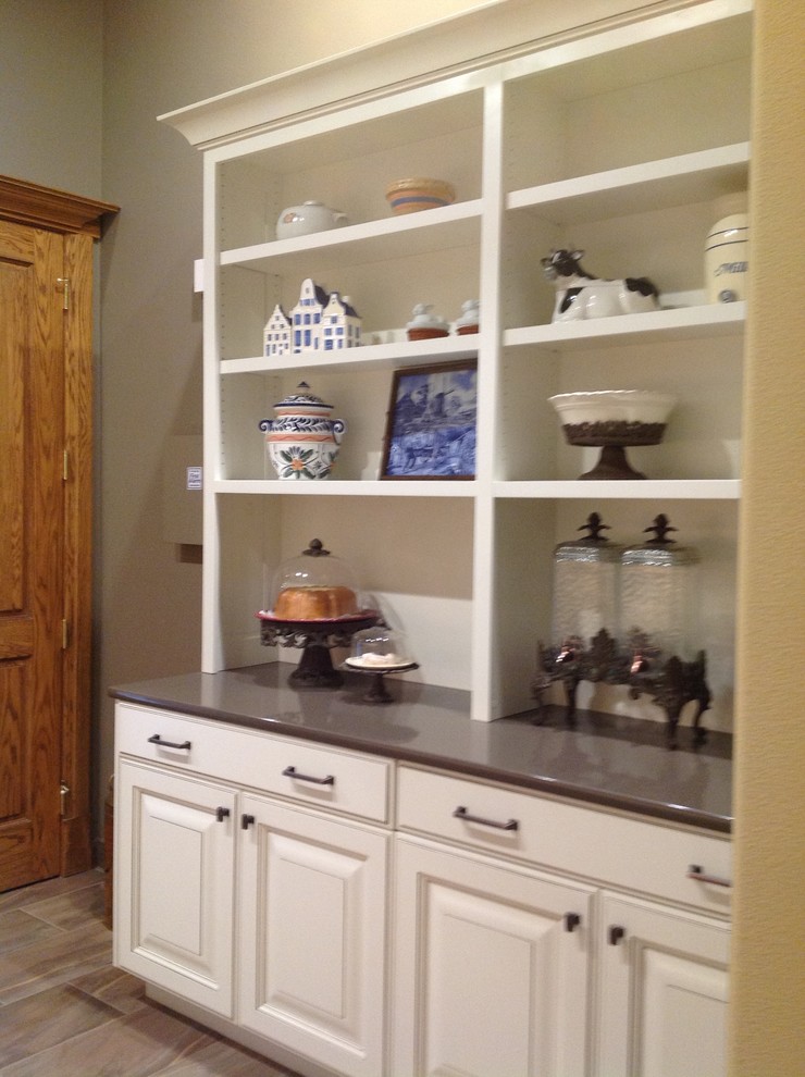 Example of a mid-sized transitional single-wall porcelain tile and brown floor kitchen pantry design in Boise with a single-bowl sink, raised-panel cabinets, white cabinets, beige backsplash, ceramic backsplash and stainless steel appliances