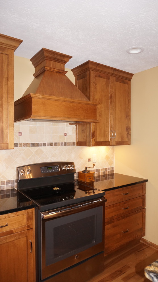 Immagine di una grande cucina rustica con lavello sottopiano, ante con riquadro incassato, ante in legno scuro, top in granito e pavimento in legno massello medio
