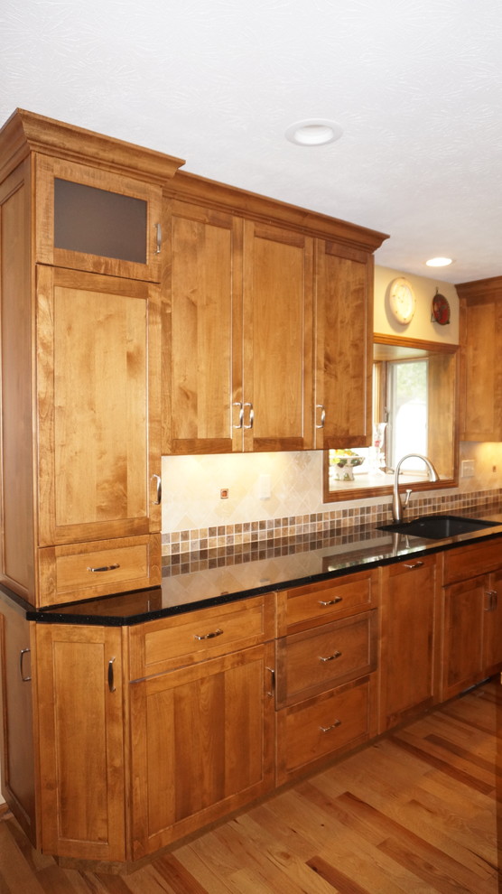Esempio di una grande cucina rustica con lavello sottopiano, ante con riquadro incassato, top in granito, pavimento in legno massello medio e ante in legno scuro