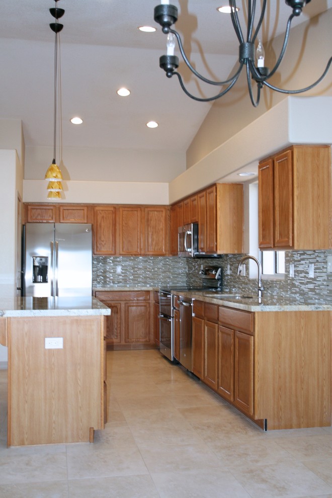 Moderne Küche in U-Form mit hellbraunen Holzschränken, Granit-Arbeitsplatte, Glasrückwand, Küchengeräten aus Edelstahl und Travertin in Phoenix