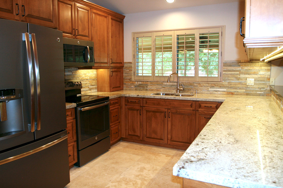 Modern inredning av ett u-kök, med en dubbel diskho, skåp i mellenmörkt trä, granitbänkskiva, beige stänkskydd och travertin golv