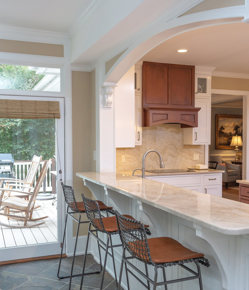 Large elegant u-shaped medium tone wood floor and brown floor eat-in kitchen photo in Raleigh with a farmhouse sink, shaker cabinets, white cabinets, beige backsplash, stone slab backsplash, stainless steel appliances, an island, beige countertops and quartzite countertops