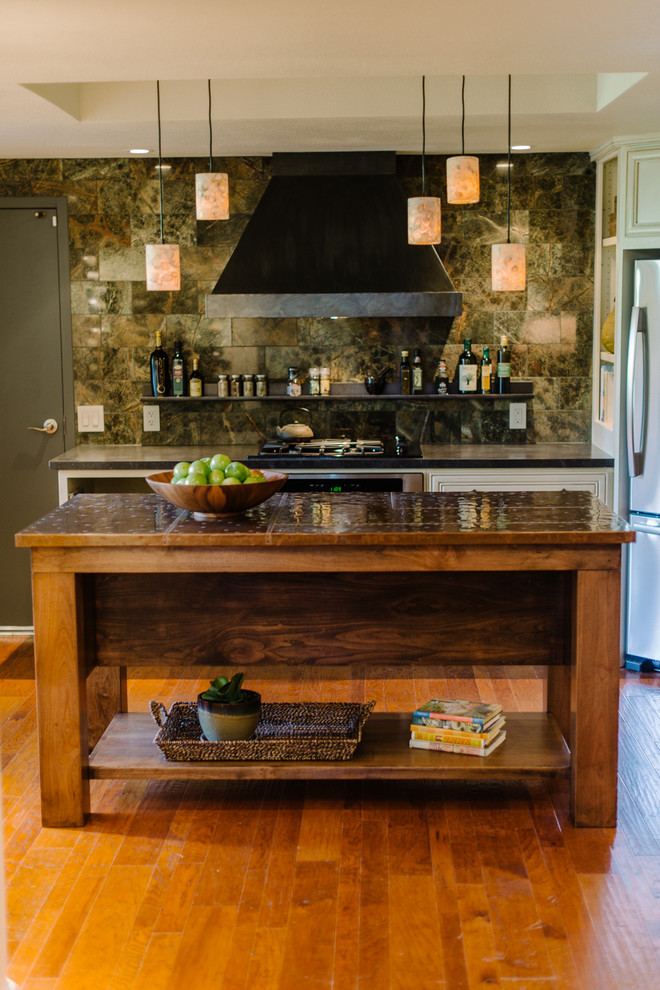 Cette photo montre une cuisine chic en L avec une crédence verte, un électroménager en acier inoxydable et un plan de travail en cuivre.