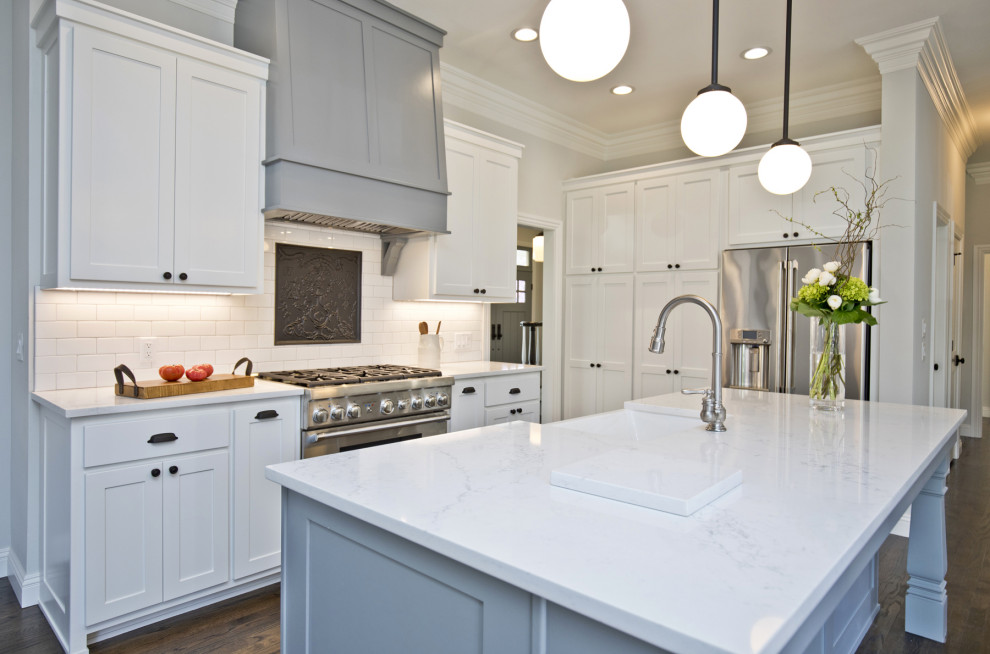 Inspiration for a mid-sized timeless single-wall enclosed kitchen remodel with a farmhouse sink, shaker cabinets, white cabinets, granite countertops, white backsplash, subway tile backsplash, an island and white countertops