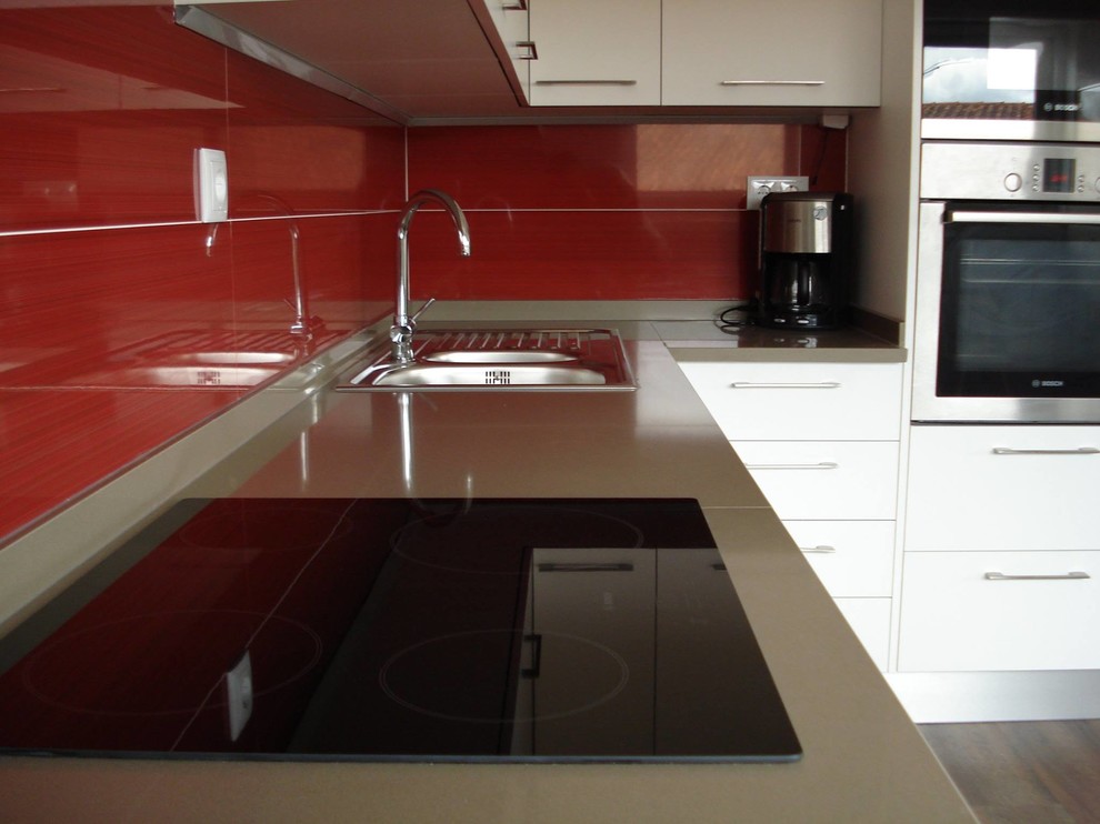 Medium sized modern galley enclosed kitchen in Other with a double-bowl sink, flat-panel cabinets, white cabinets, engineered stone countertops, red splashback, mosaic tiled splashback, stainless steel appliances and no island.