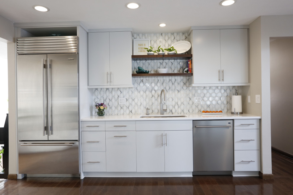 Exempel på ett mellanstort modernt vit vitt kök och matrum, med en undermonterad diskho, släta luckor, vita skåp, bänkskiva i kvartsit, vitt stänkskydd, stänkskydd i mosaik, vita vitvaror och mellanmörkt trägolv