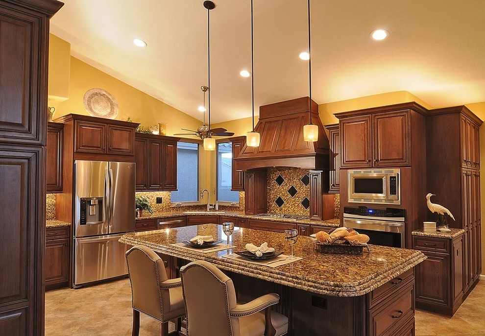 Eat-in kitchen - large transitional l-shaped ceramic tile eat-in kitchen idea in Phoenix with a double-bowl sink, raised-panel cabinets, medium tone wood cabinets, granite countertops, multicolored backsplash, ceramic backsplash, stainless steel appliances and an island