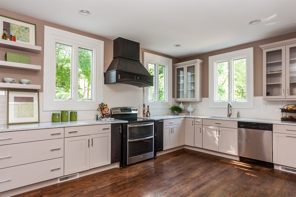 Example of a large transitional l-shaped dark wood floor kitchen design in Raleigh with an undermount sink, recessed-panel cabinets, marble countertops, white backsplash, porcelain backsplash, stainless steel appliances and no island