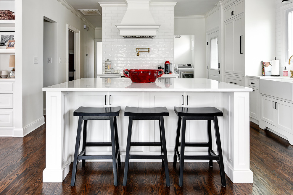 Eat-in kitchen - small transitional galley dark wood floor eat-in kitchen idea in Jacksonville with a farmhouse sink, recessed-panel cabinets, white cabinets, quartz countertops, white backsplash, ceramic backsplash, stainless steel appliances, an island and white countertops