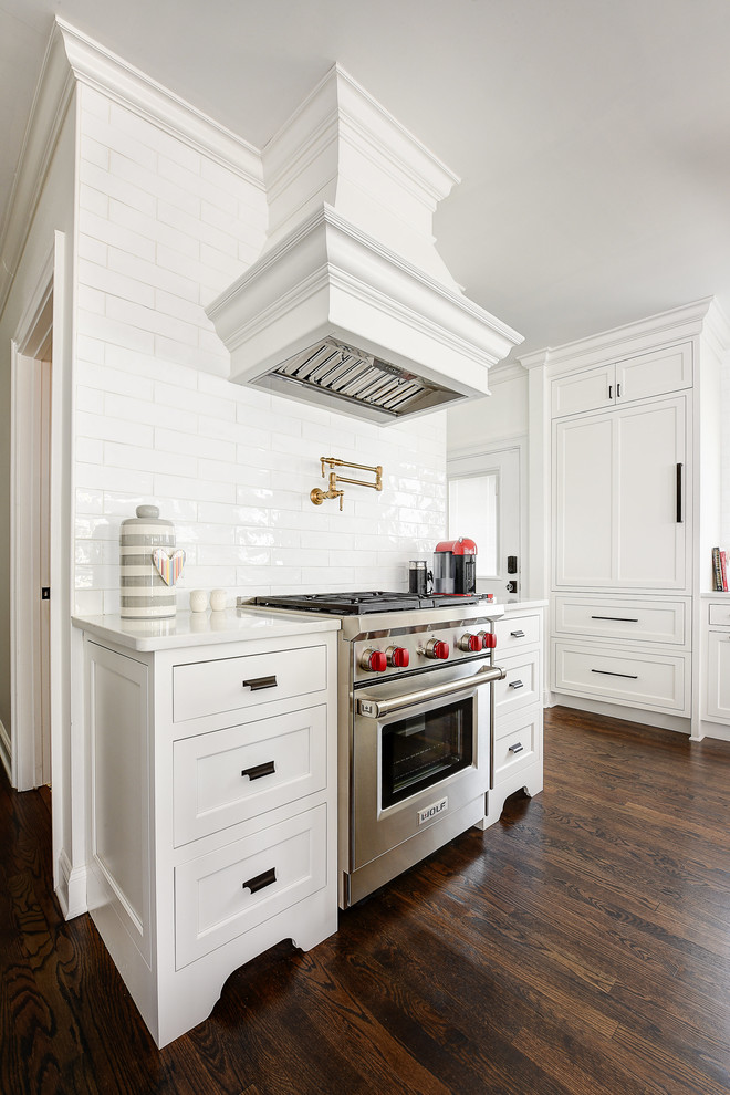 Bild på ett litet vintage kök, med en rustik diskho, luckor med infälld panel, vita skåp, bänkskiva i kvarts, vitt stänkskydd, stänkskydd i keramik, rostfria vitvaror, mörkt trägolv och en köksö