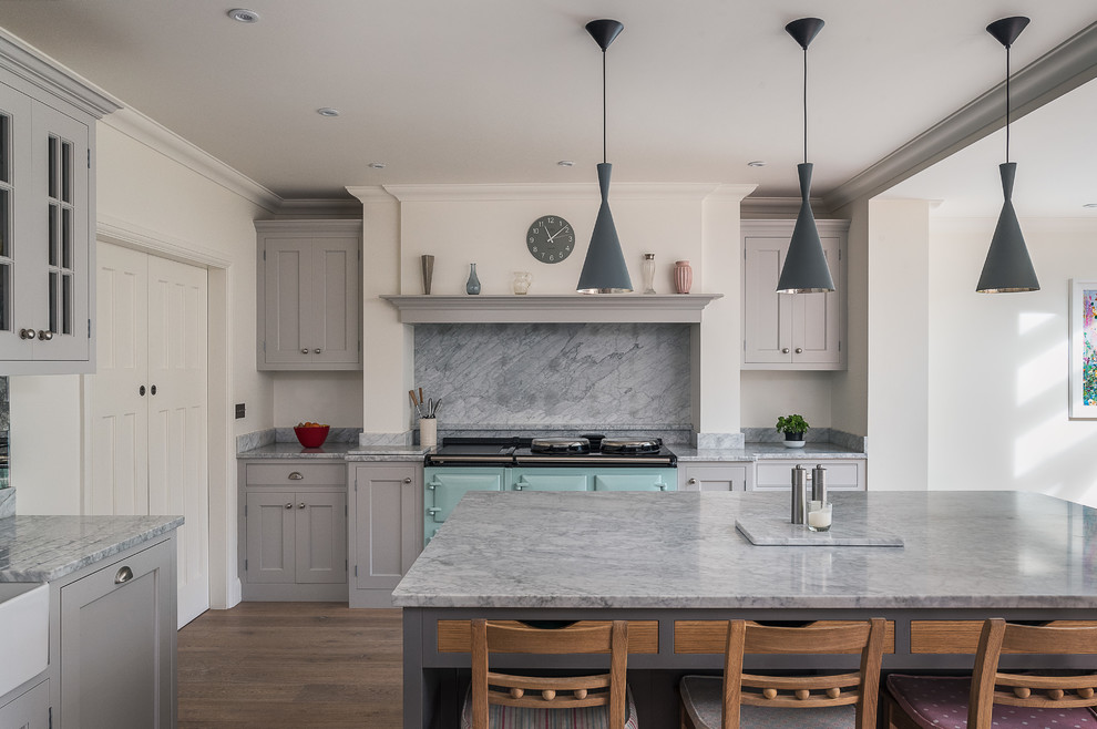 Klassisk inredning av ett stort kök, med en rustik diskho, grå skåp, marmorbänkskiva, grått stänkskydd, stänkskydd i sten, integrerade vitvaror, mellanmörkt trägolv, en köksö och skåp i shakerstil